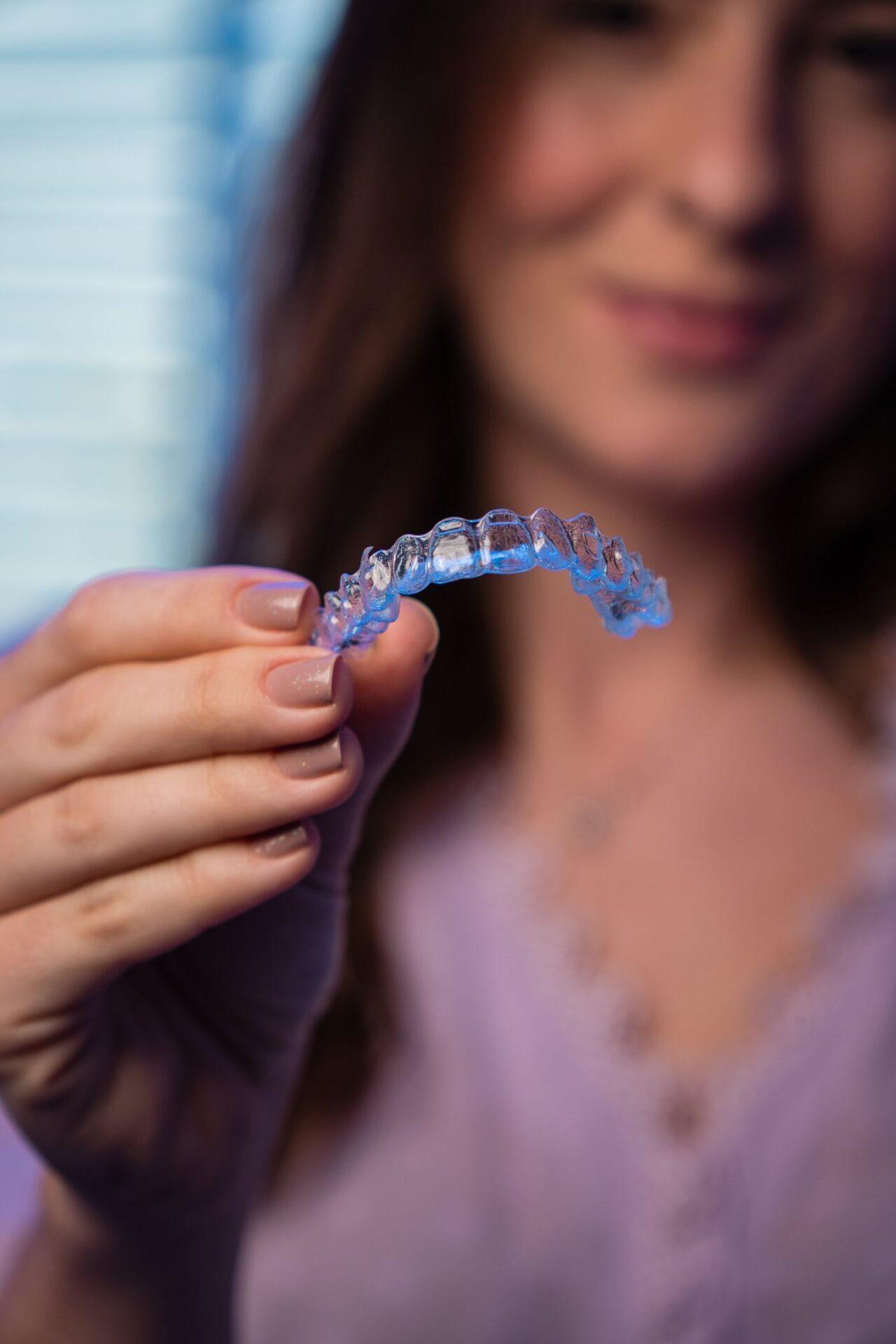 Dental Invisalign in Tillsonburg: patient holding a clear aligner at Family Dentistry on Brock